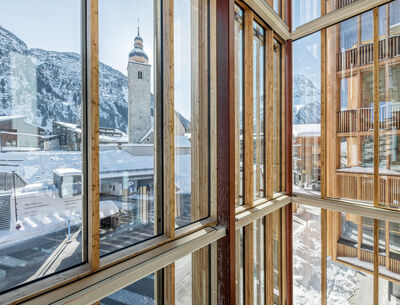 Ein Blick durch große Fenster eines modernen Gebäudes mit Holzrahmen.