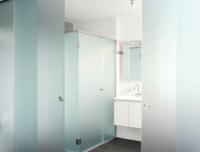 Badezimmer mit einer halbtransparenten Schiebetür aus Glas.