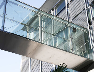 verglaste Fußgängerbrücke, die zwei Gebäude verbindet, mit einer Struktur aus Stahl und Glas