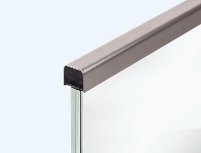 Detailansicht eines Handlaufs aus Metall, der auf einer Glaskante montiert ist.